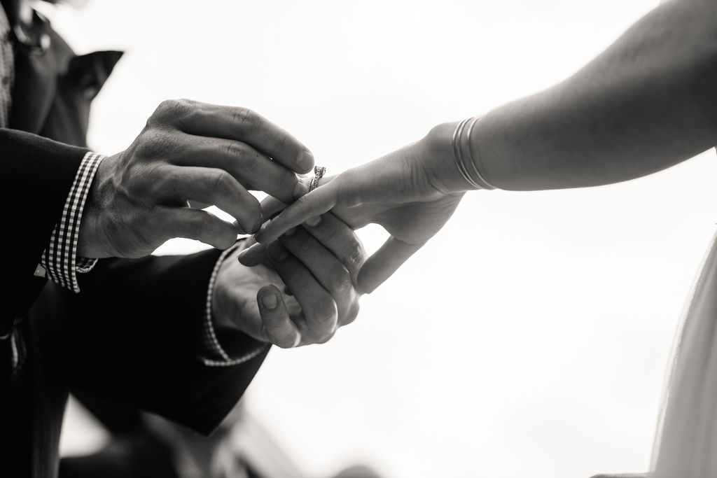 a man placing a diamond ring on his partner's hand 