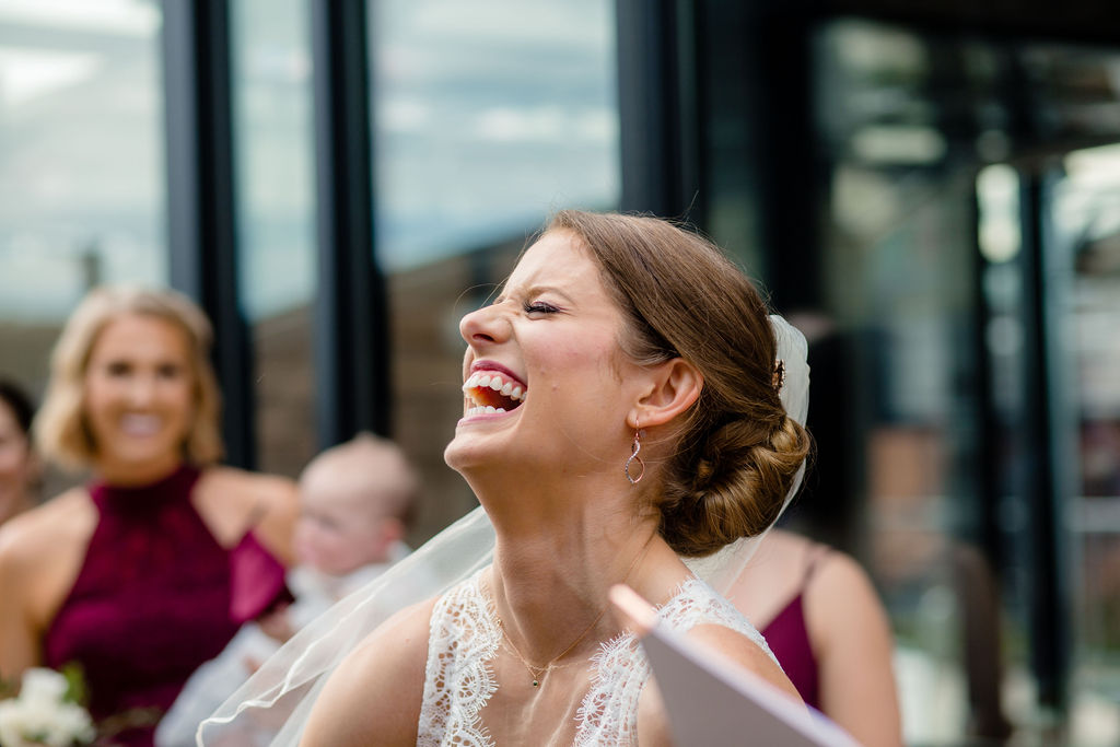 a woman laughing on the day of her wedding 