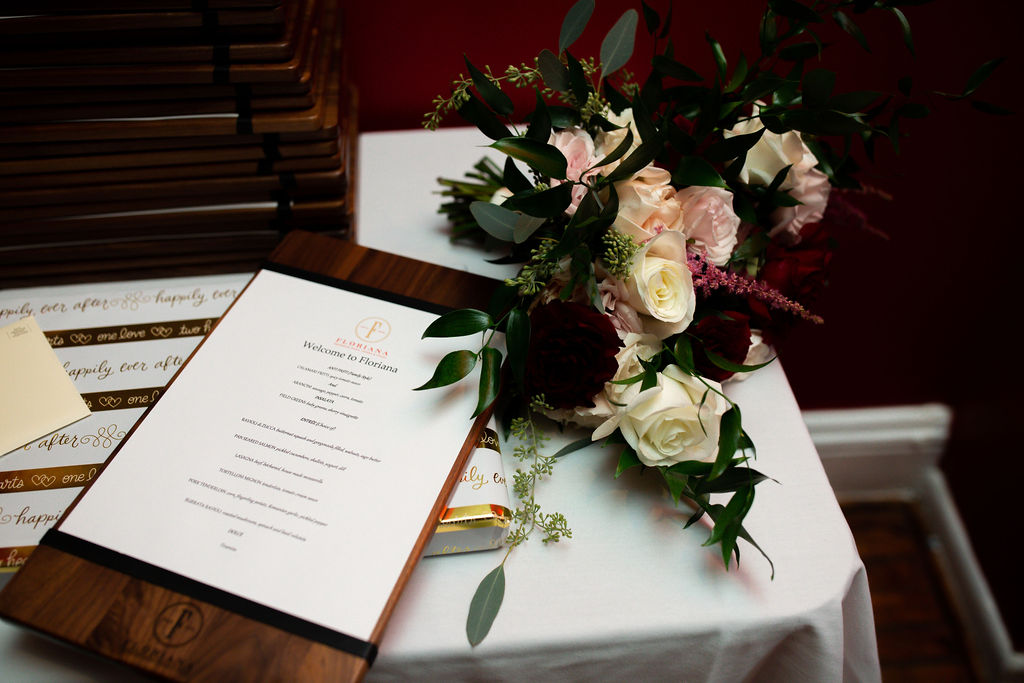 a restaurant menu on a white tablecloth next to a bouquet of flowers 