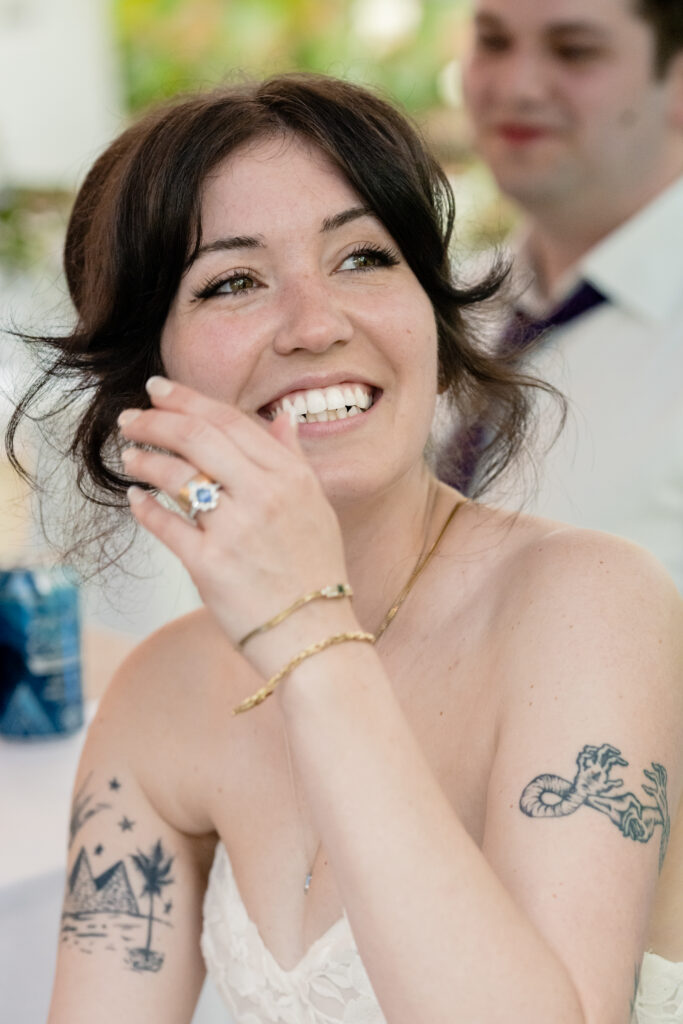 A newlywed in a wedding dress laughing 