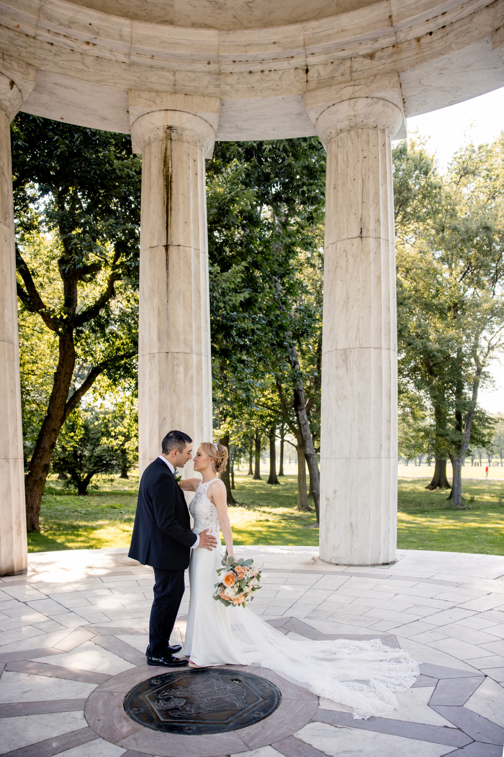 a bride and groom in a pavilion taking couple wedding portraits 