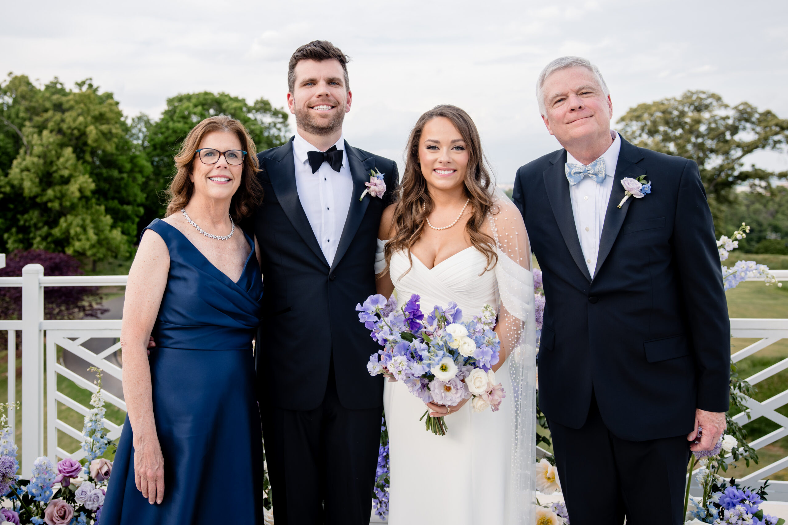 a bride and groom taking wedding photos with their parents 