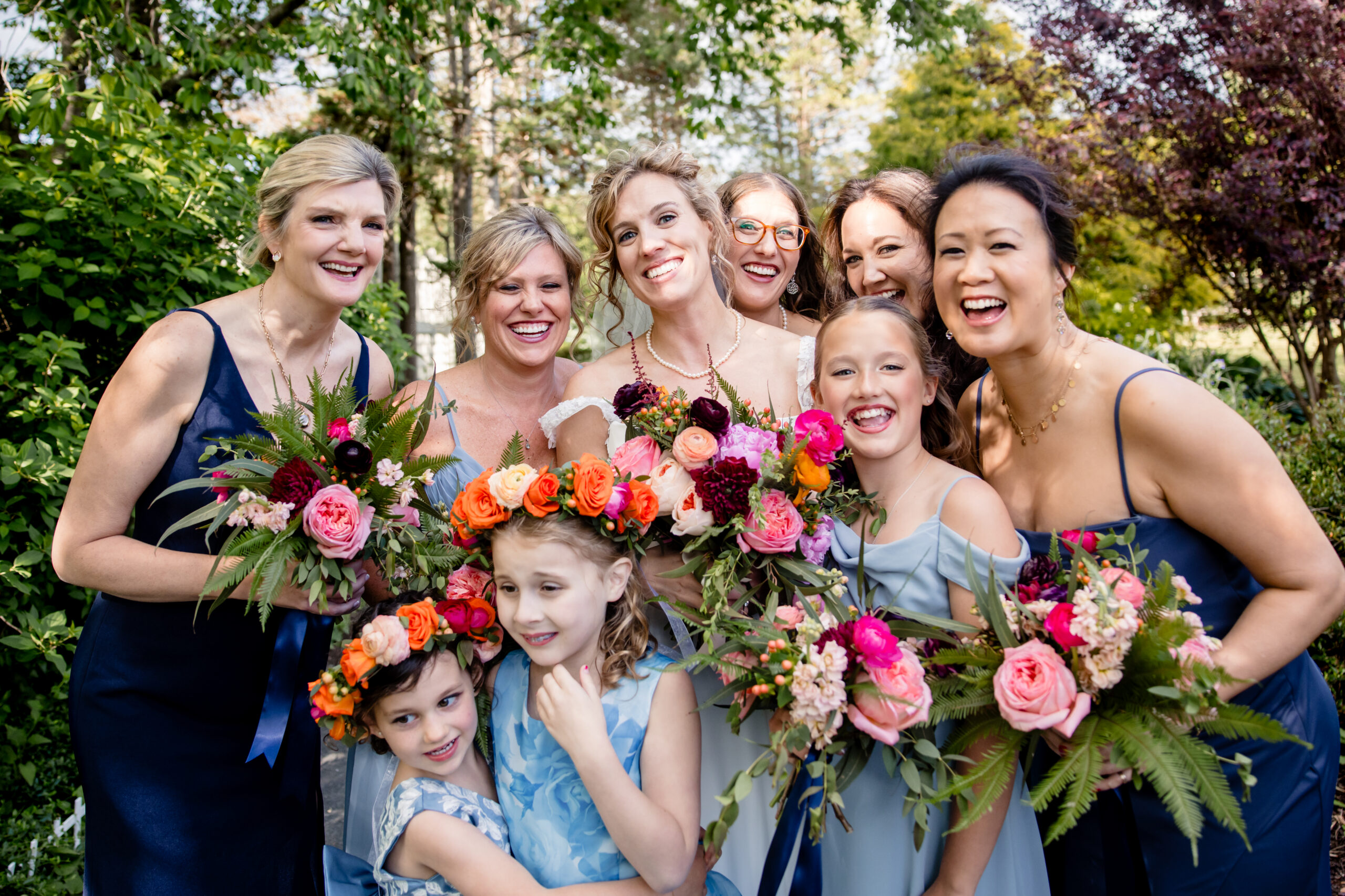 a bride taking wedding photos with her flower girls and bridesmaids