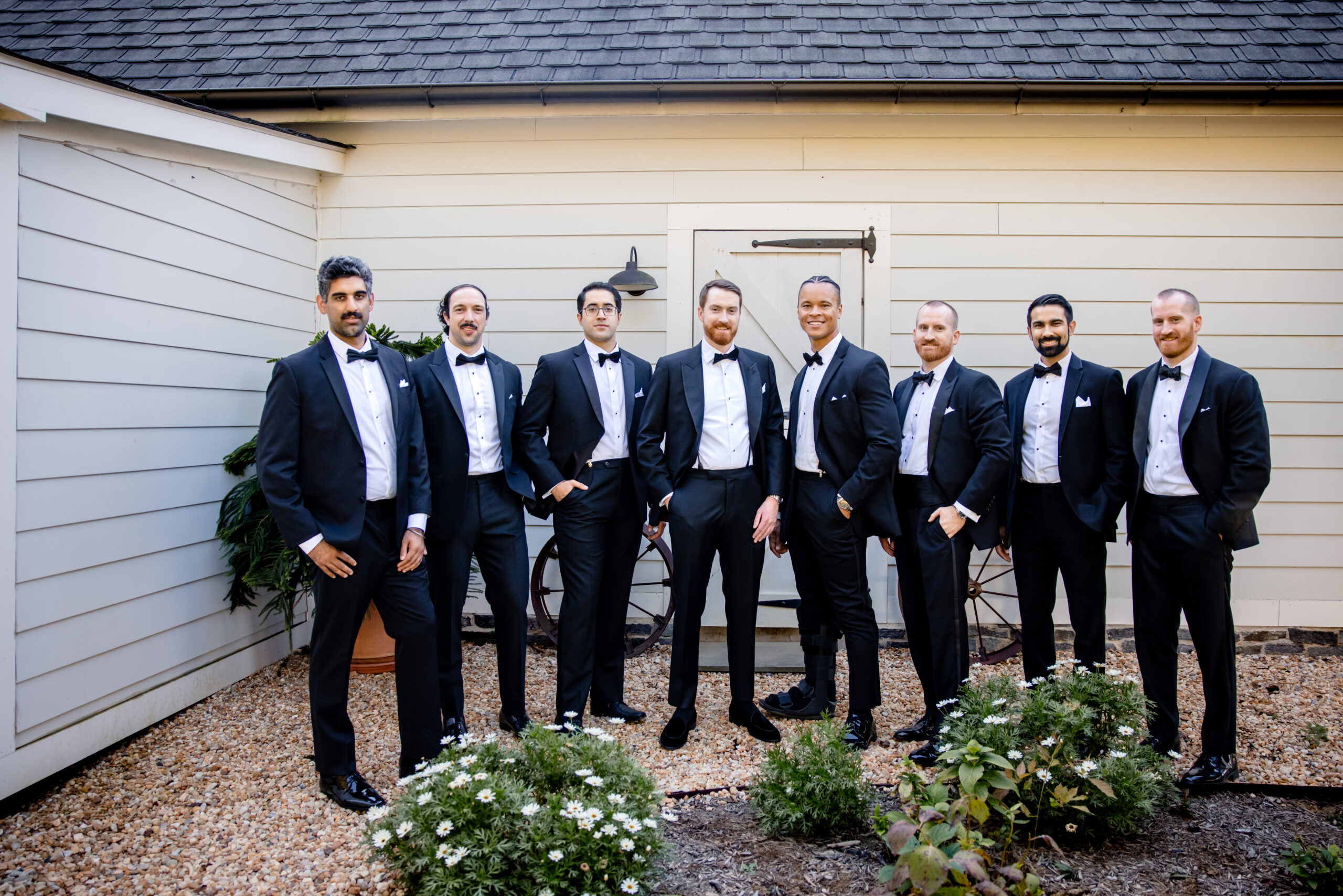 a groom taking photos with his wedding party 