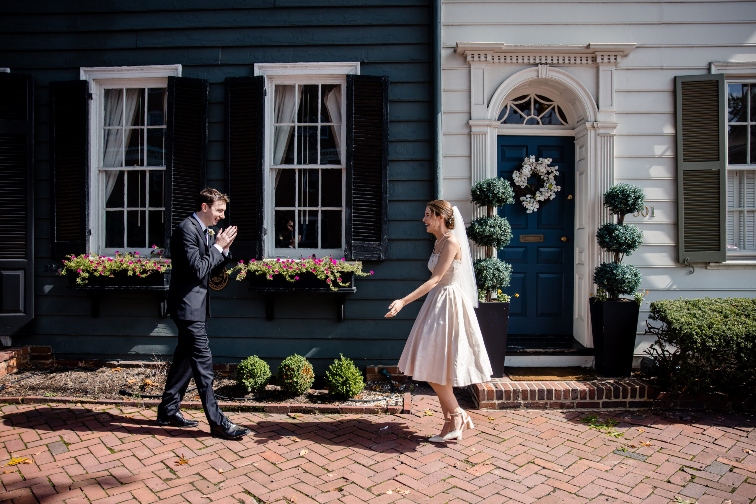 a couple walking towards each other as they share a first look together the man is very excited and holding his hands together