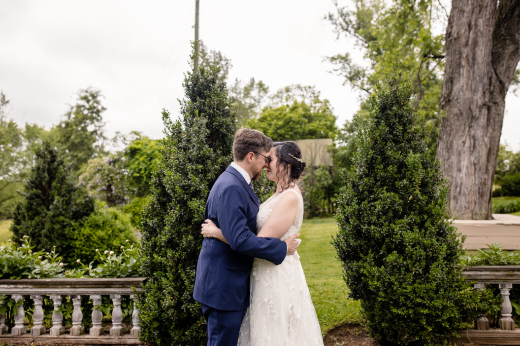 a couple embracing each other in a garden with their heads pressed together