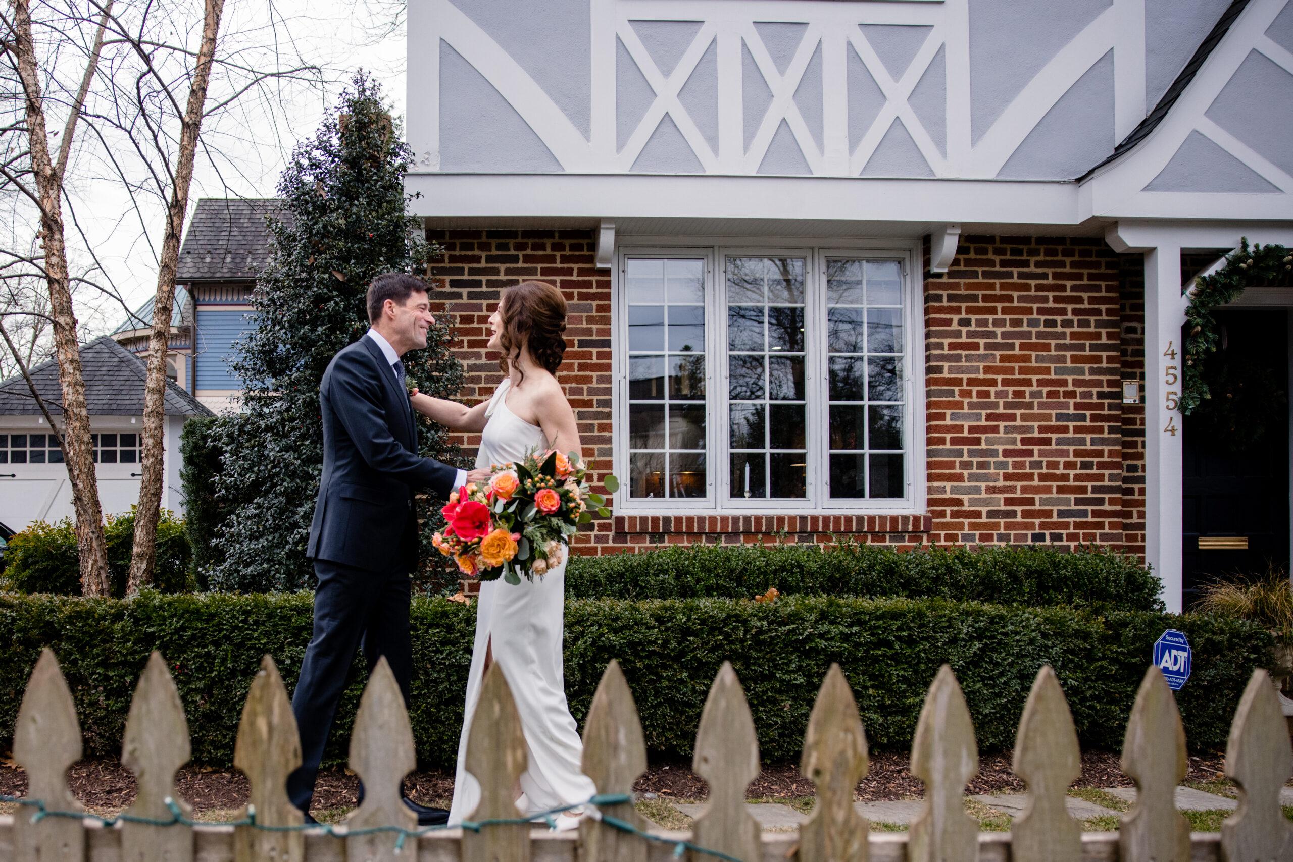 a couple sharing a first look together in front of their home on the day of their wedding