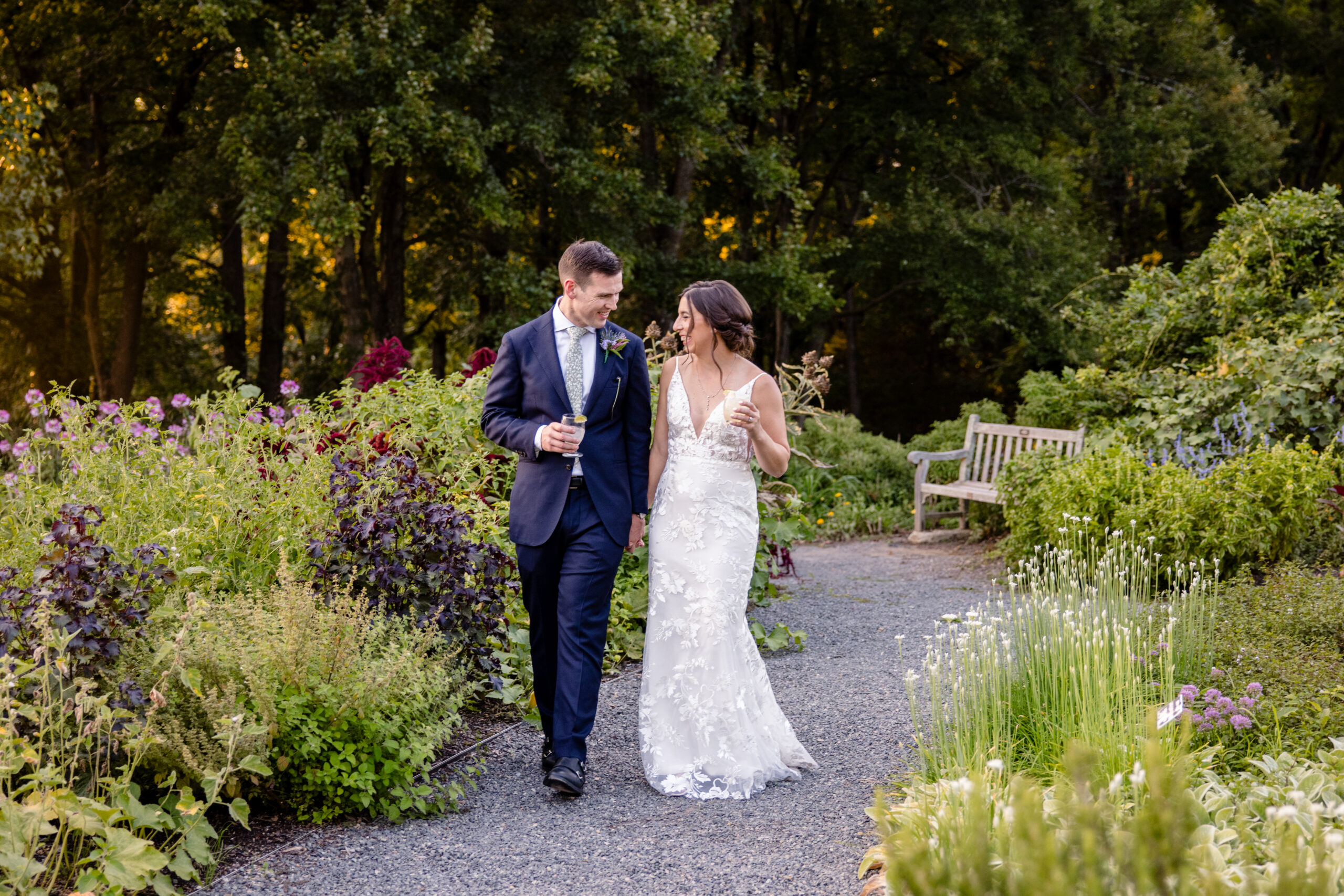 a couple walking and holding hands through the garden at The Atrium at Meadowlark Botanical Gardens on the day of their wedding 