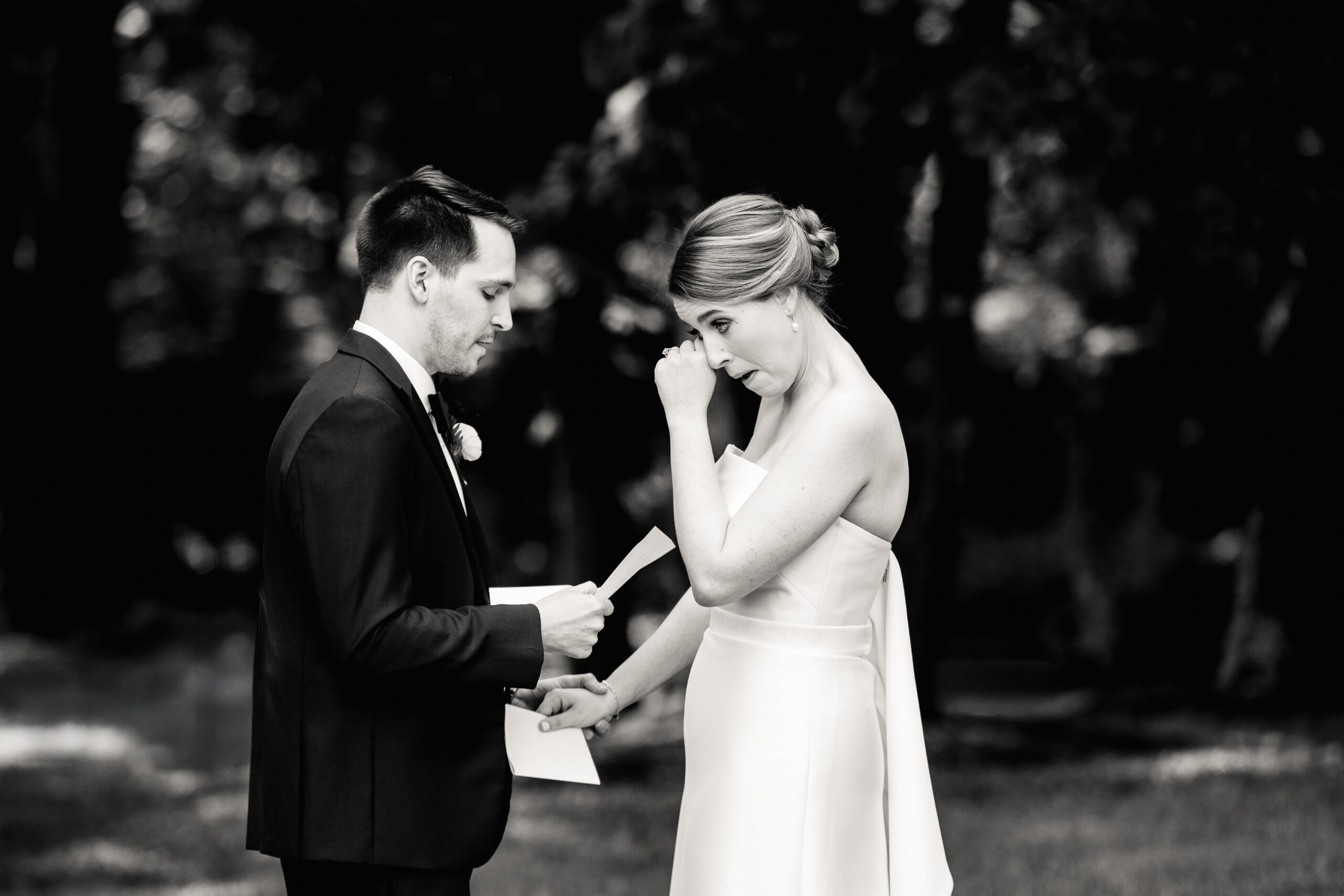 a couple reading private vows to each other in a botanical garden