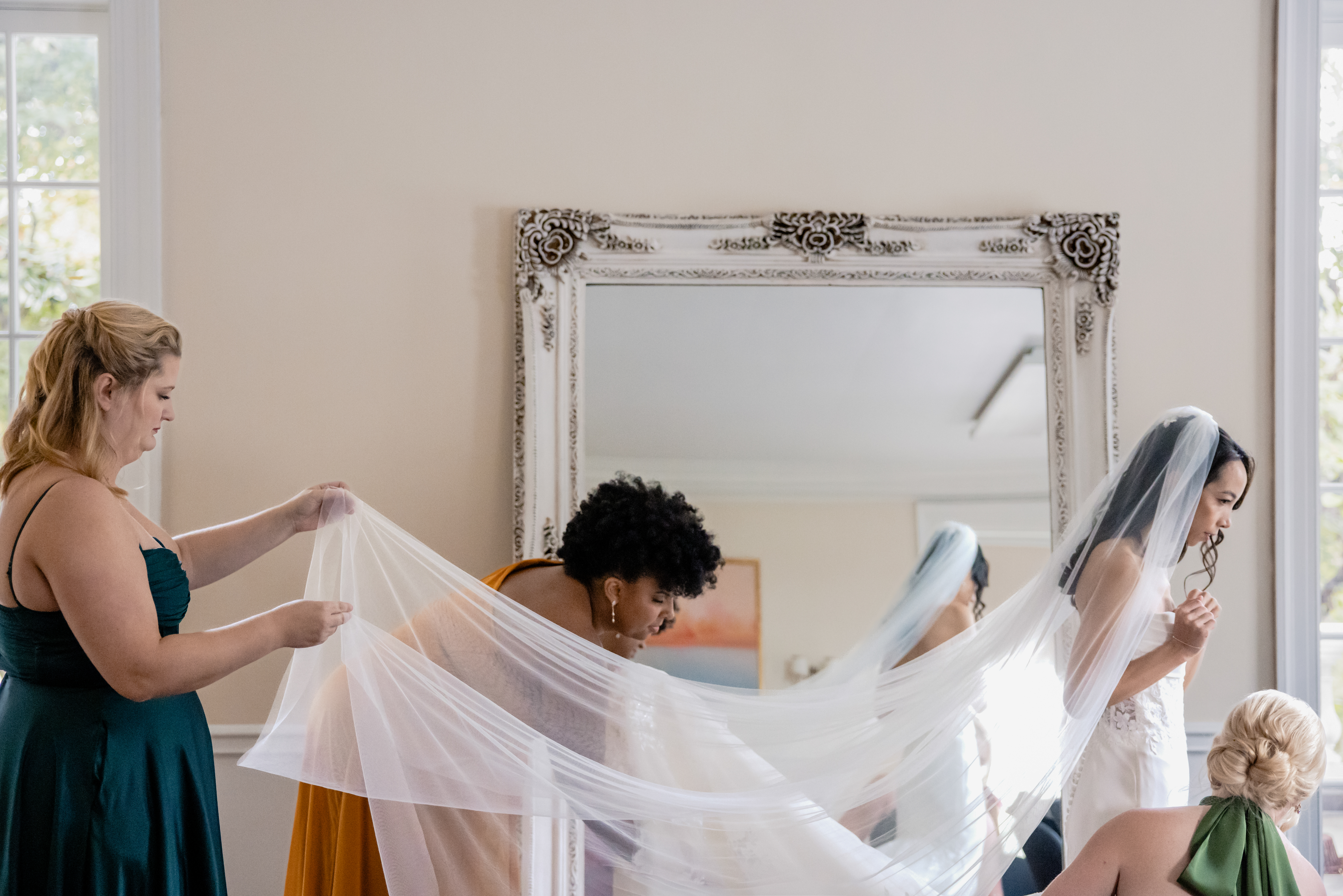 a woman getting ready for her wedding with a small wedding party helping her