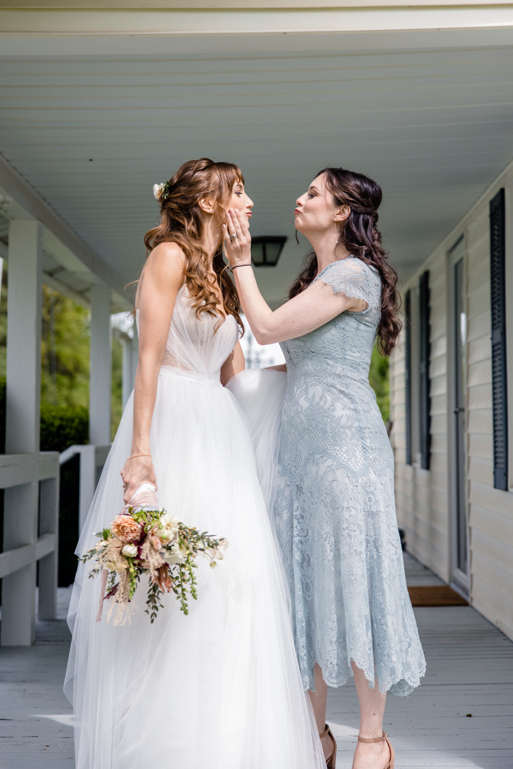 a bride standing on a porch with her bridesmaid