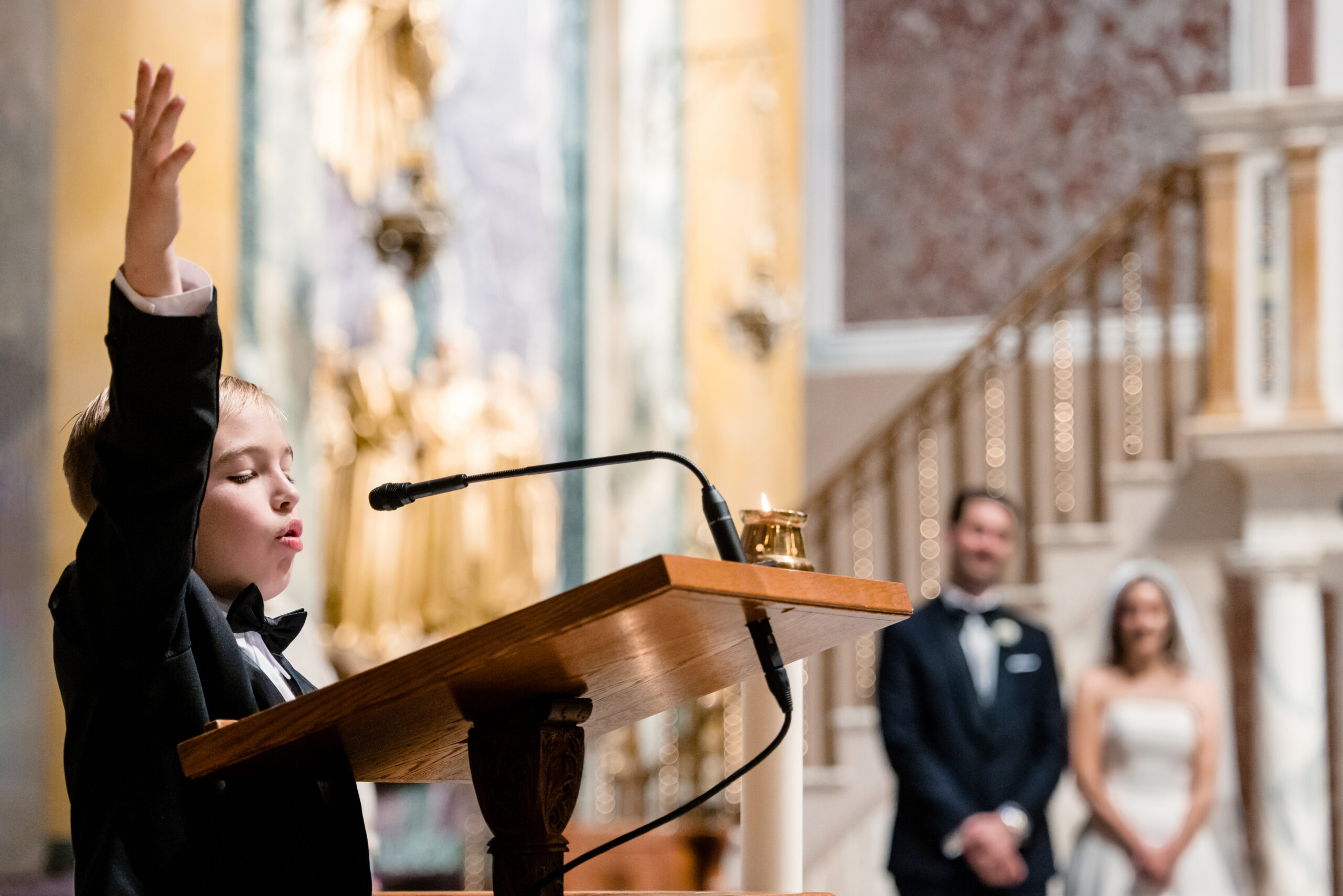 a little boy reading in a church at a wedding