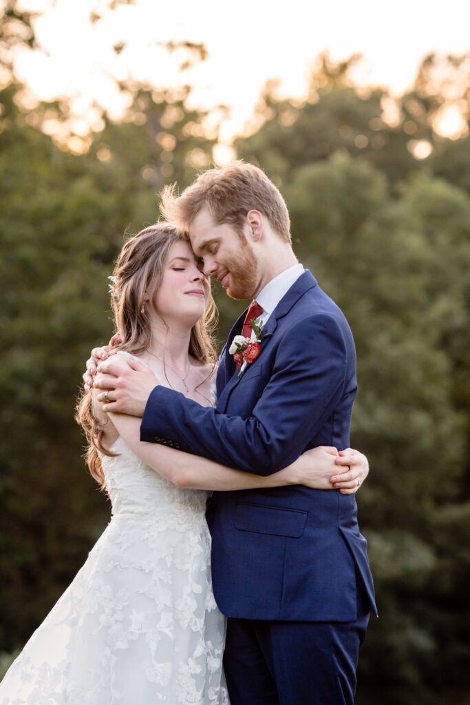 a bride and groom embracing with their heads pressed together