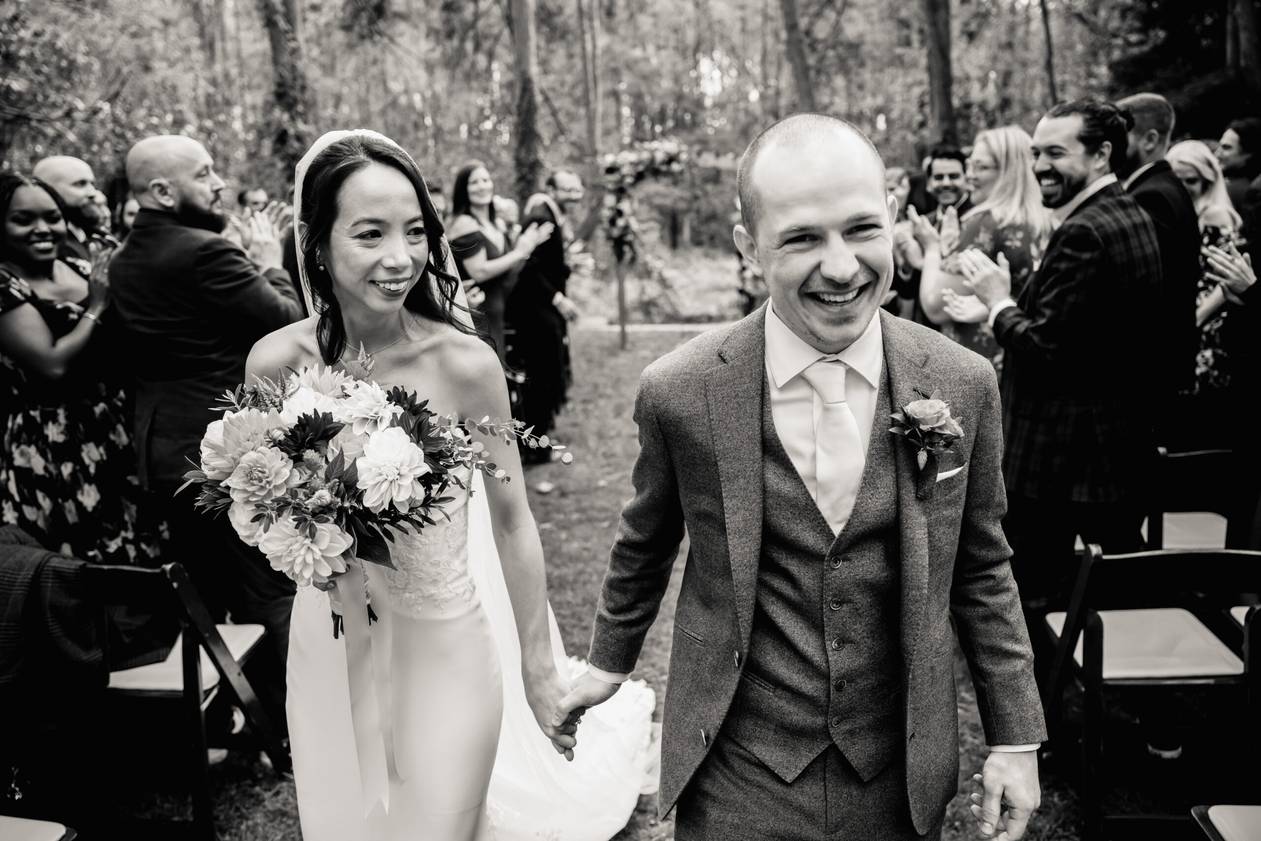 a bride and groom holding hands and walking down the aisle after their wedding ceremony