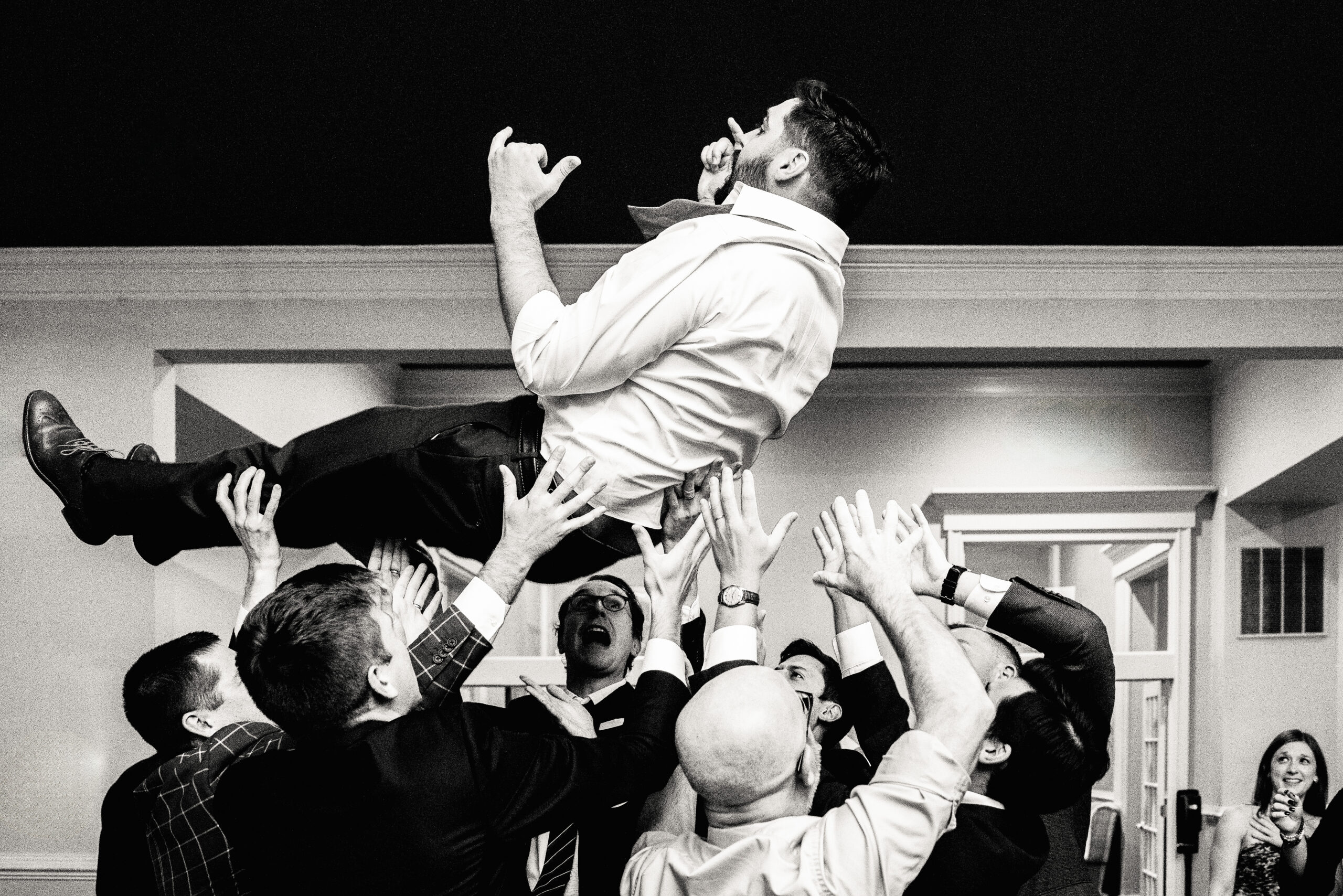 groomsmen tossing a groom into the air