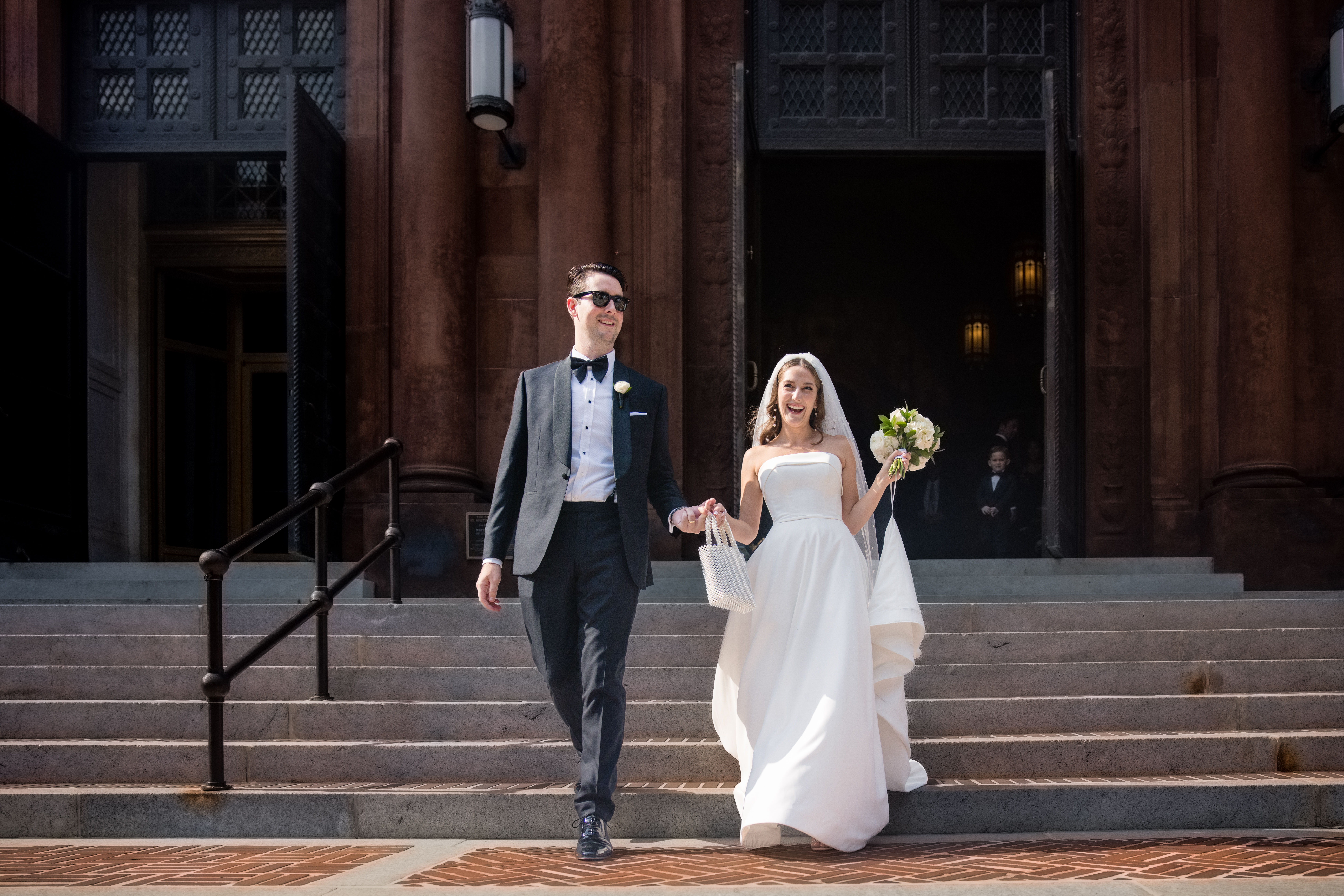 a bride and groom walking down the steps holding hands after their wedding ceremony