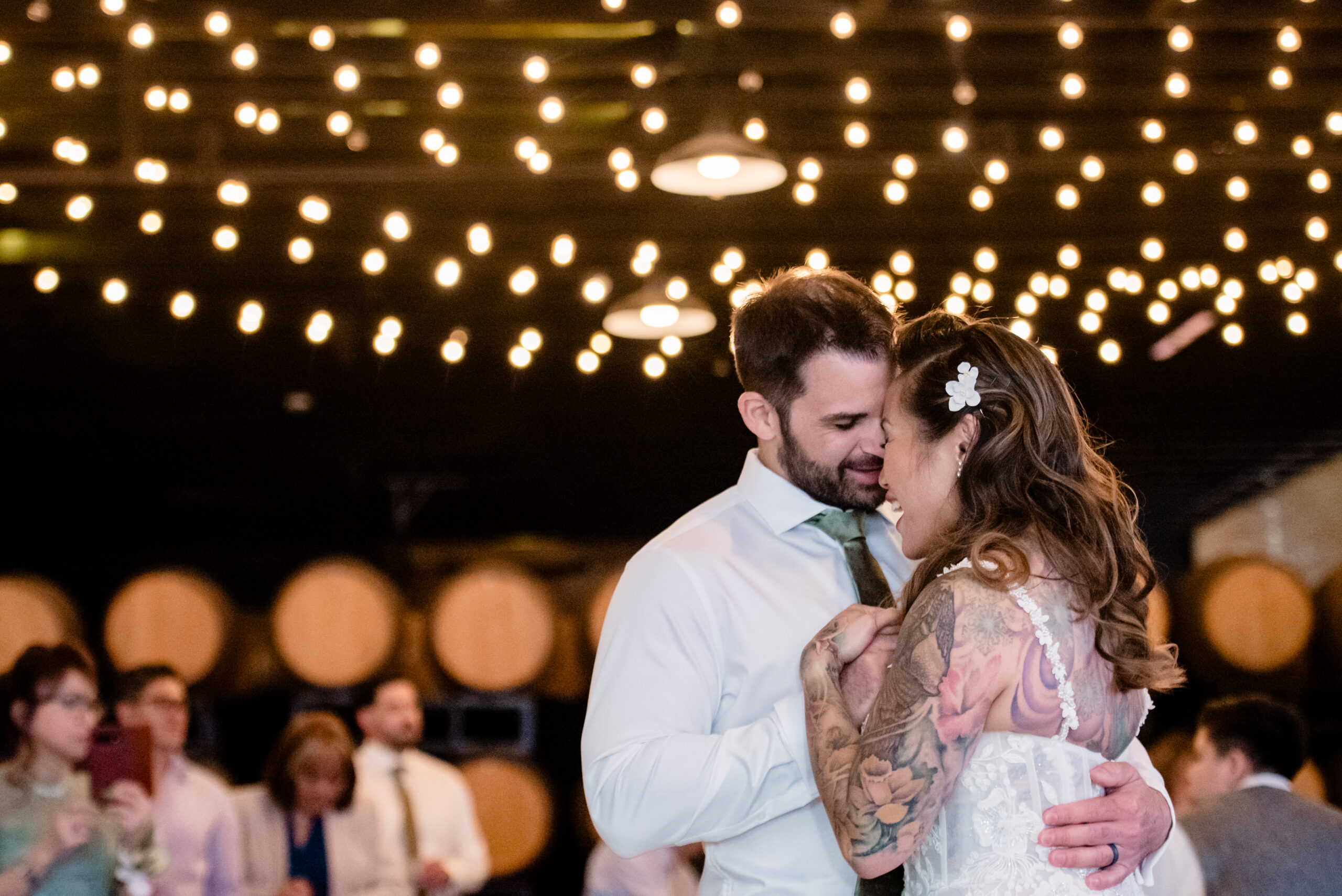 a bride and groom dancing underneath string lights at their wedding reception