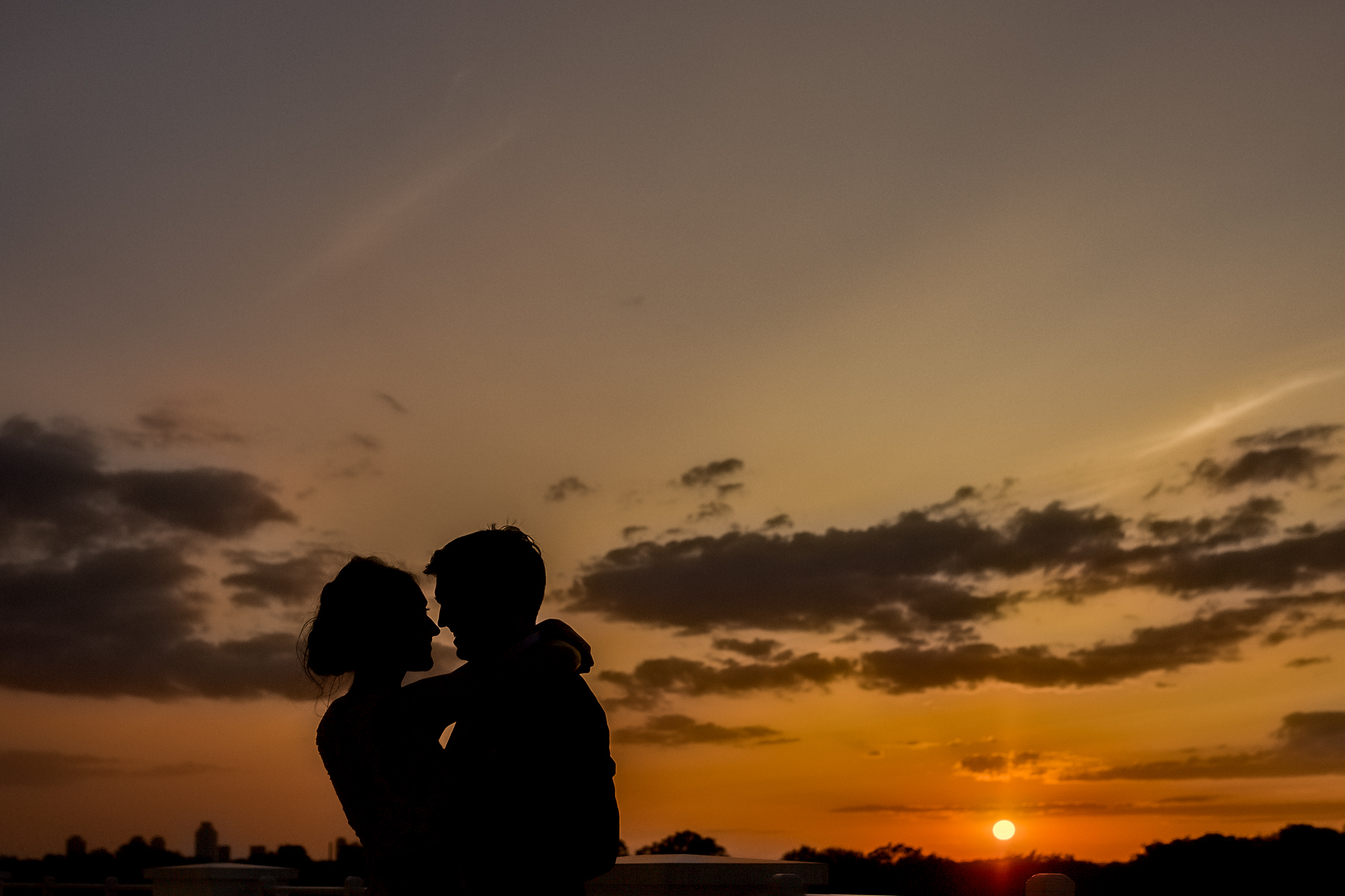 a bride and groom taking silhouette sunset portraits