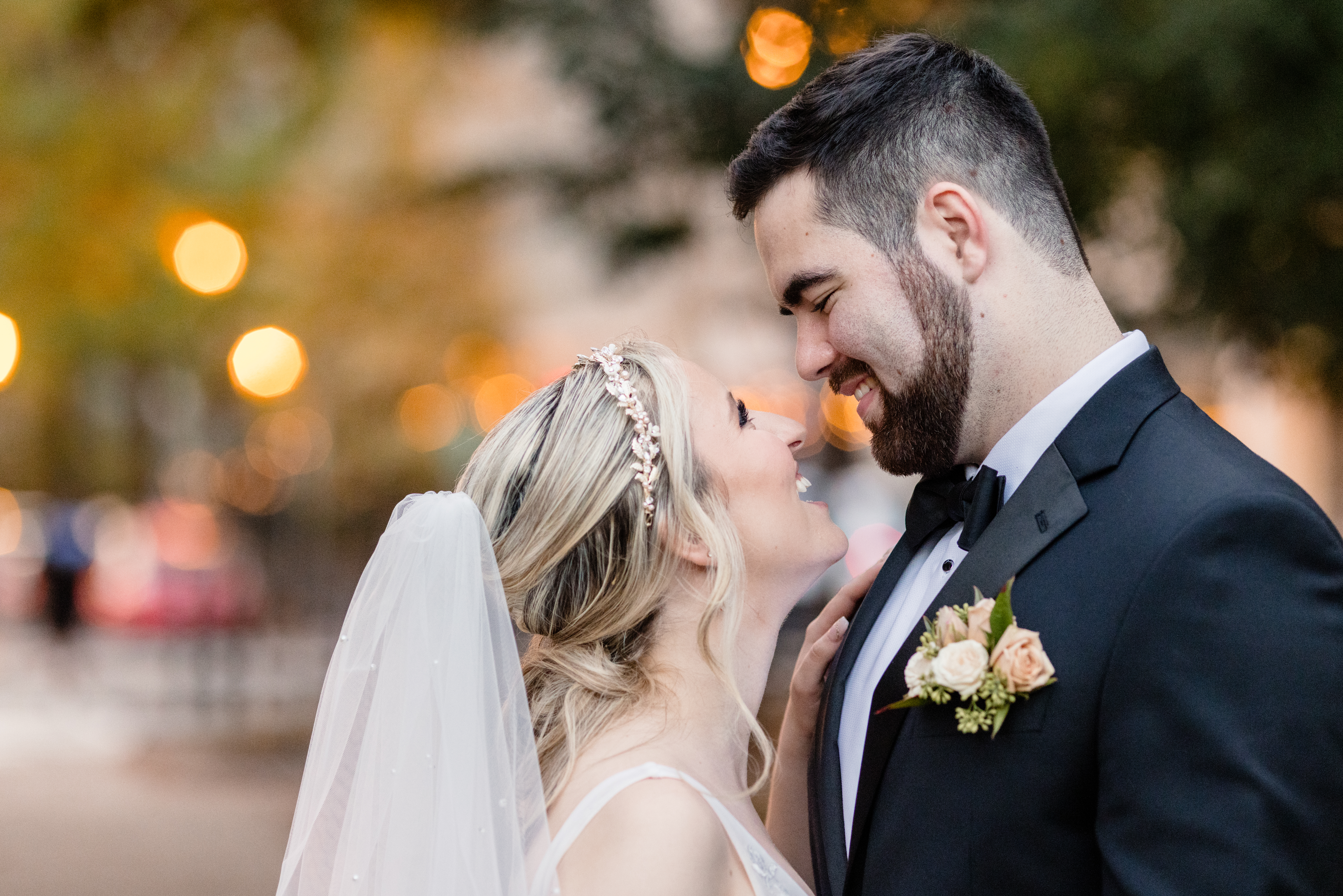 a bride and groom taking a wedding portrait and smiling at each other