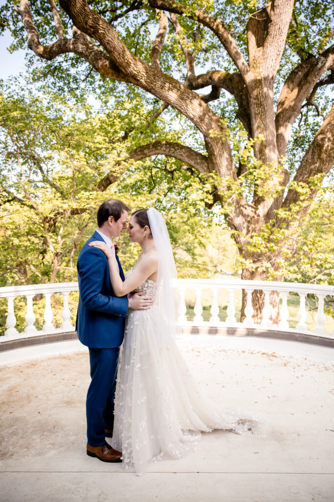 a bride and groom standing on a pavilion taking wedding portraits