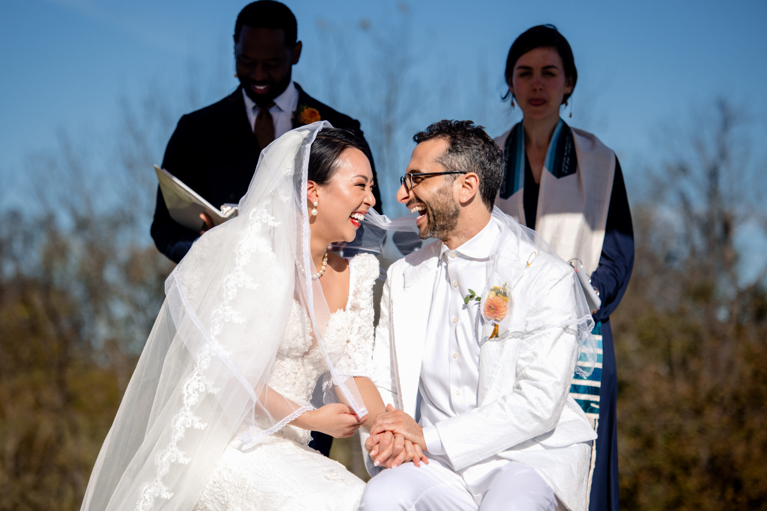 a bride and groom sitting together holding hands and laughing with one another 