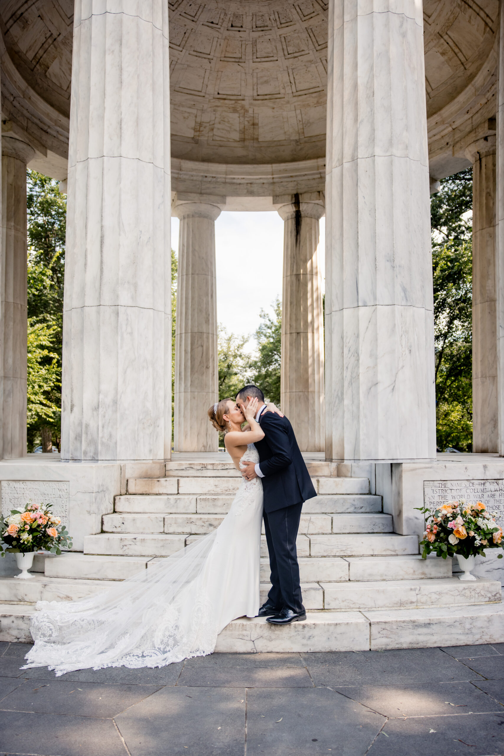 a bride and groom kissing each other on the steps of a pavilion 