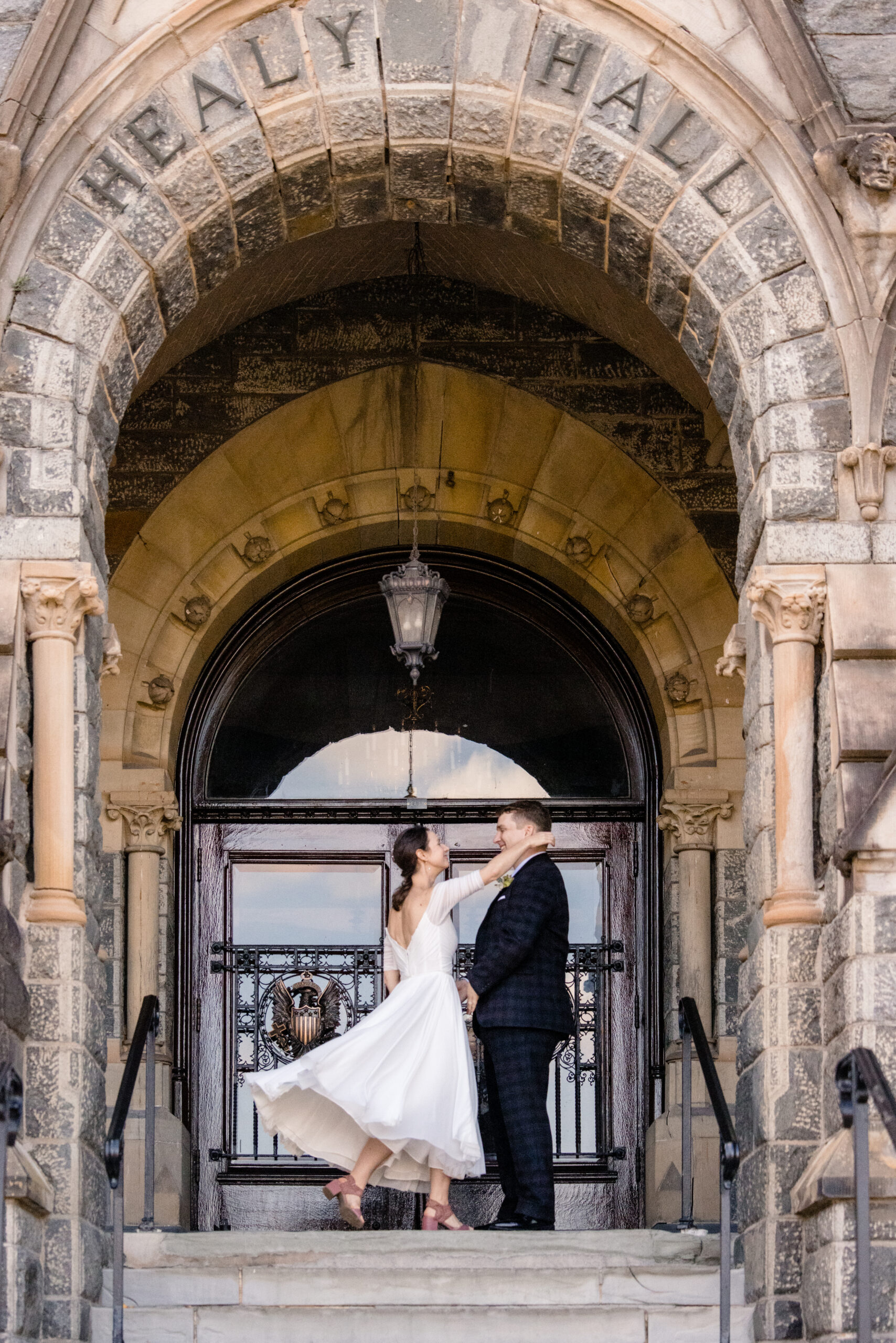 a bride and groom moving to embrace each other on the steps of a building 