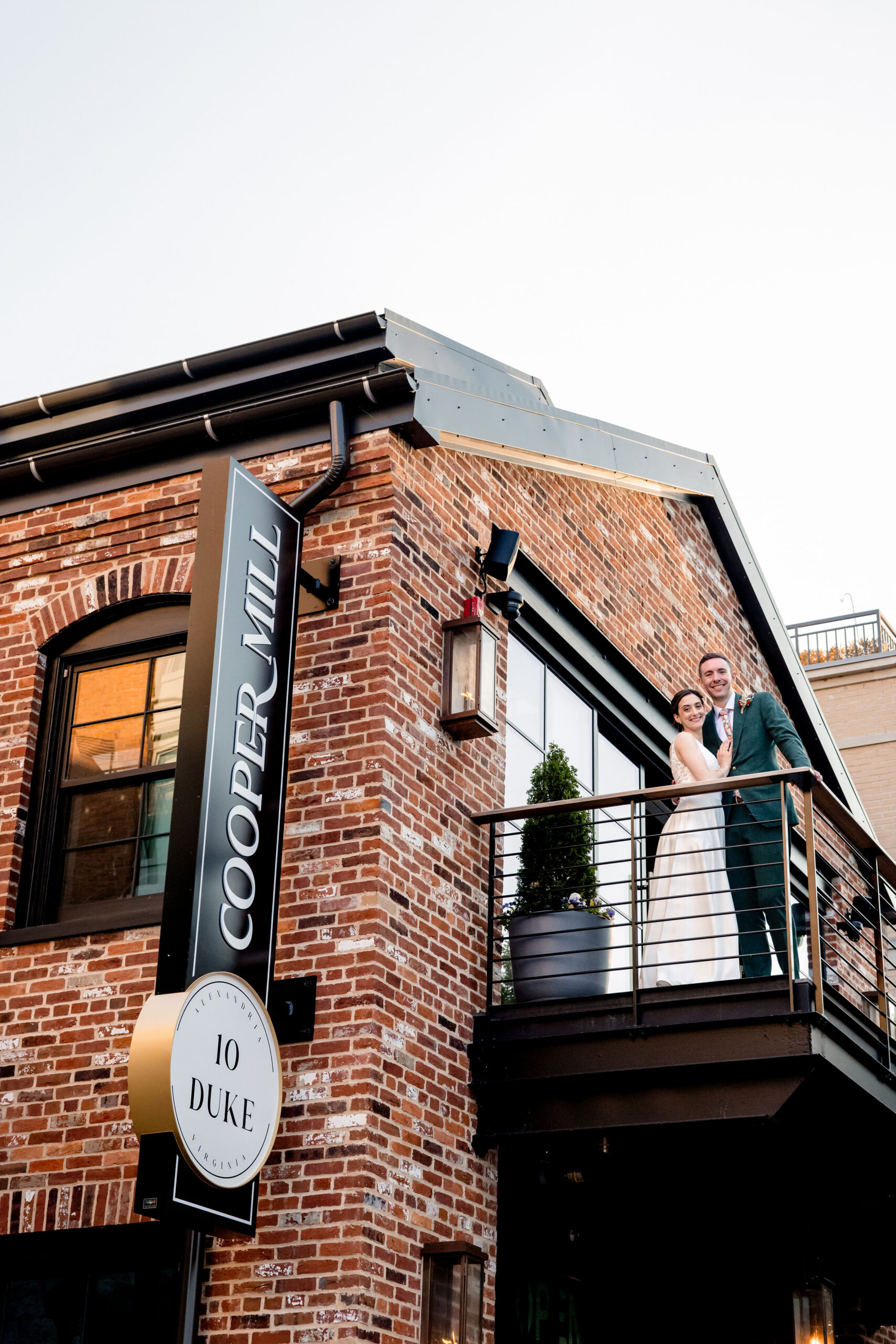 a couple on the balcony at cooper mill taking a wedding portrait 
