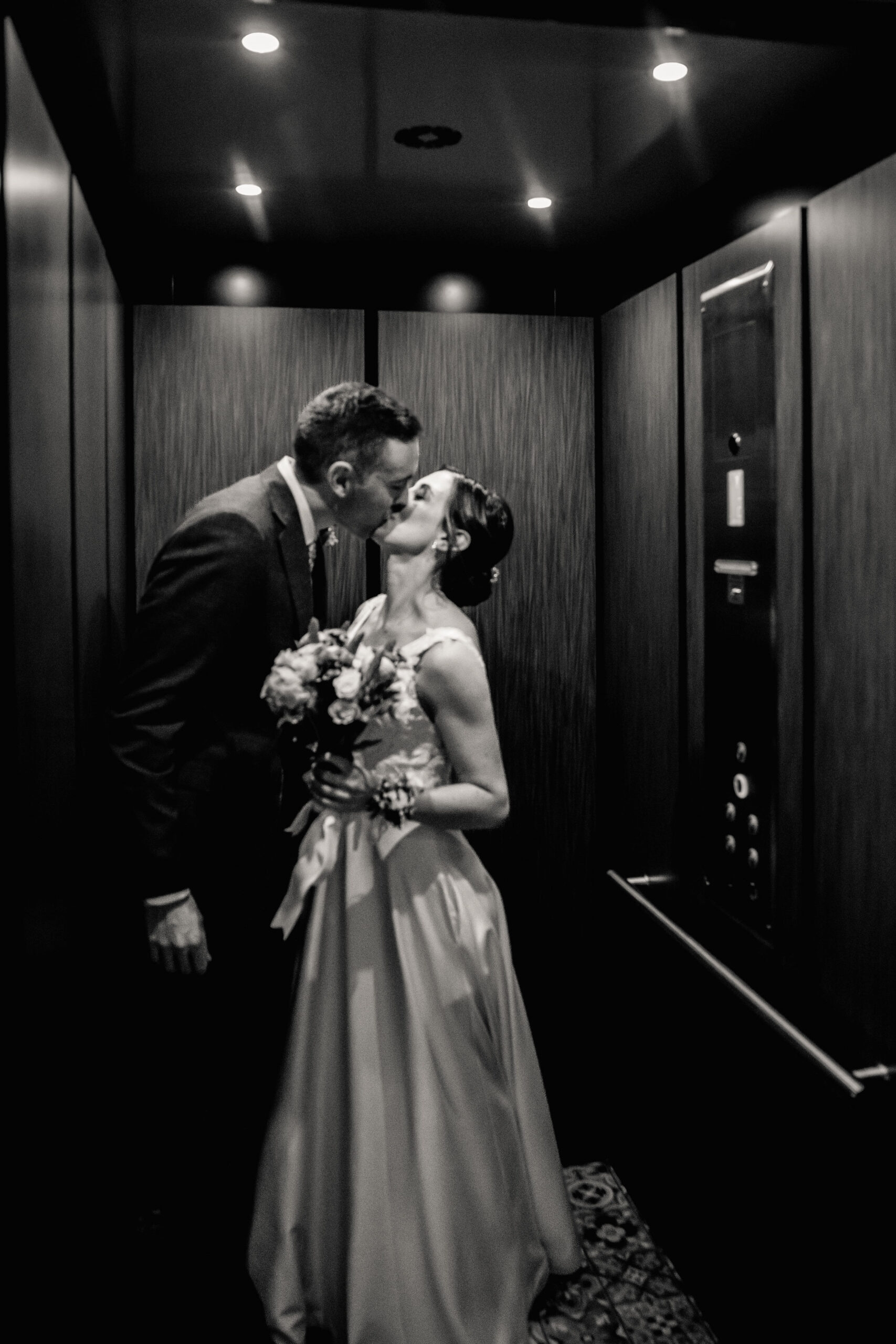 a bride and groom kissing in an elevator on the day of their wedding