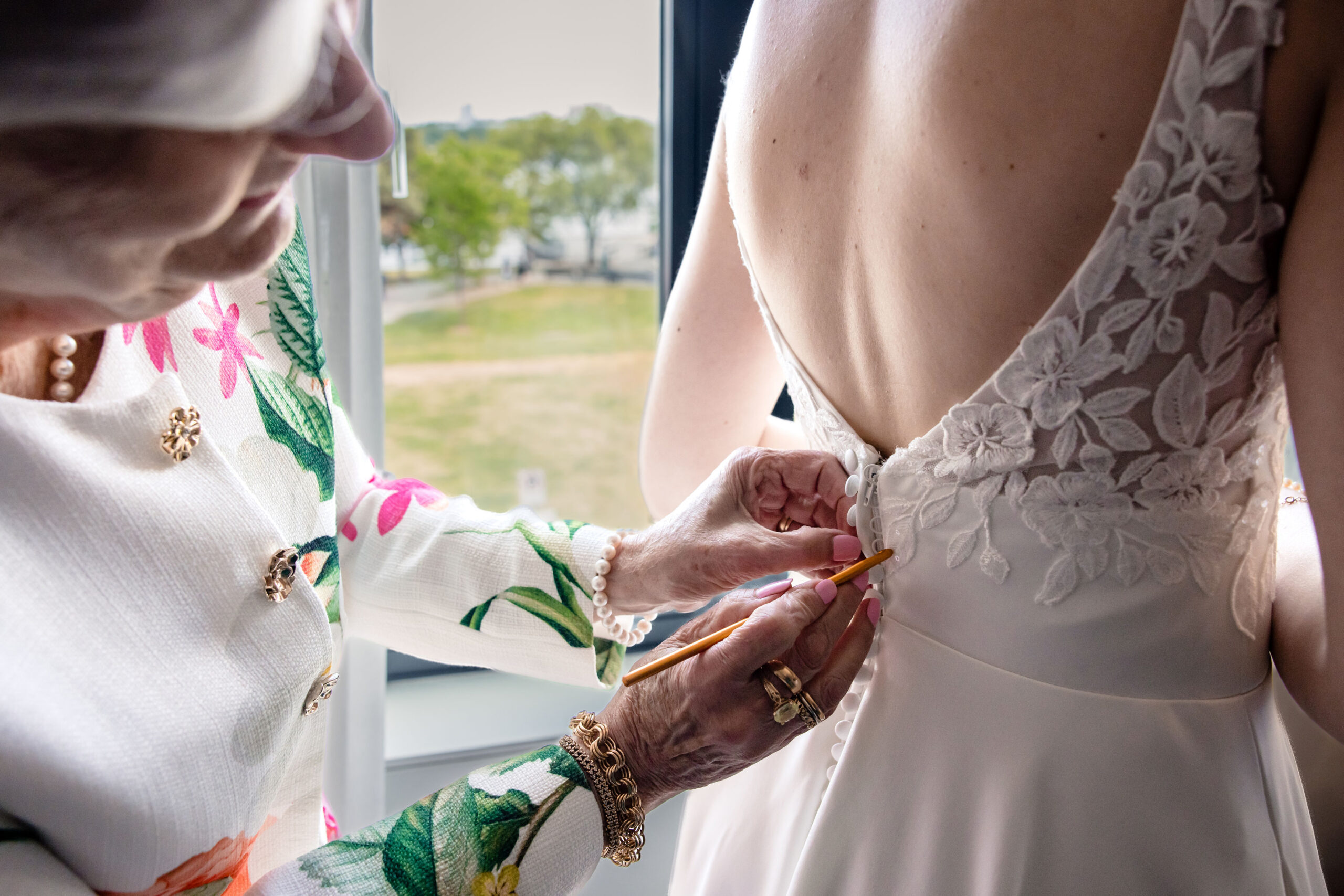 a mother helping her daughter with her wedding dress