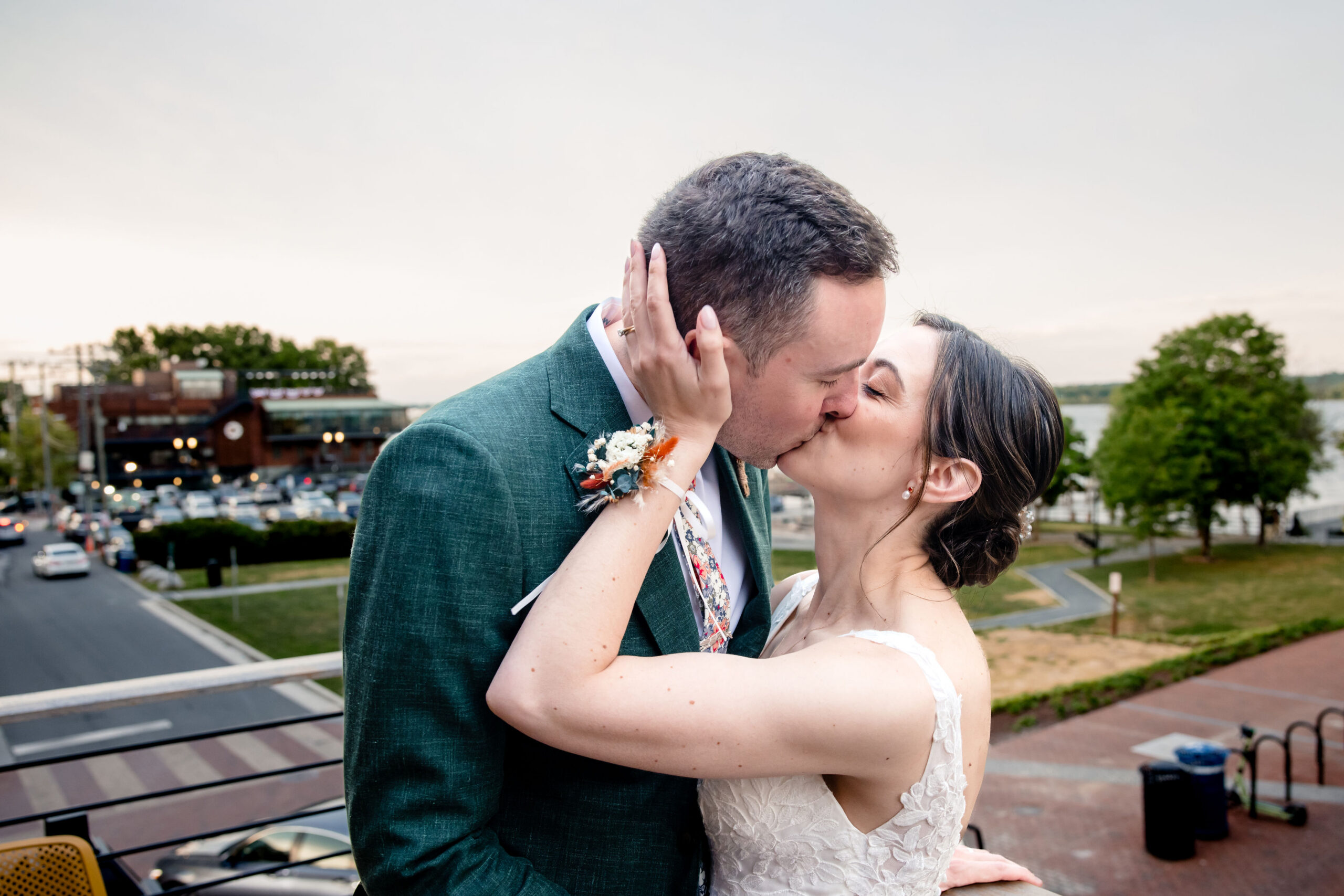 a bride and groom kissing each other on a balcony