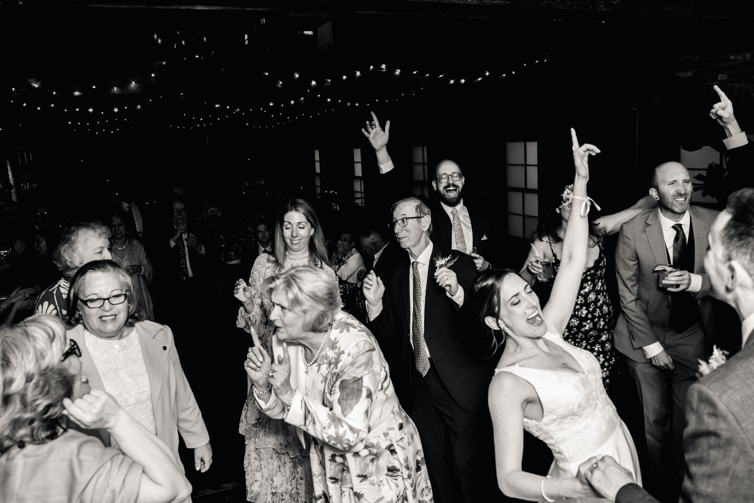 a group of people dancing together at a wedding reception 