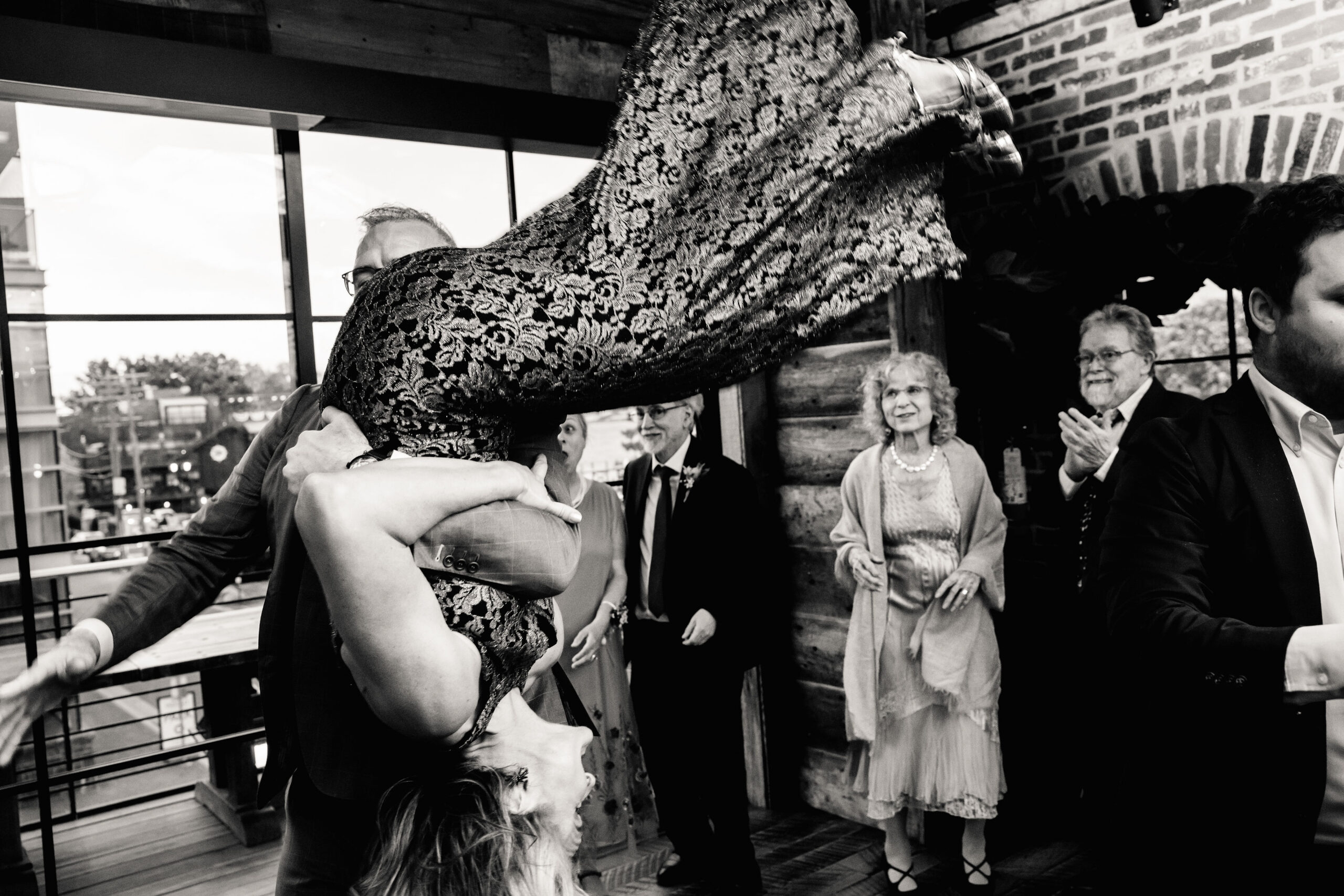 a man flipping a woman during a dance at a wedding reception 