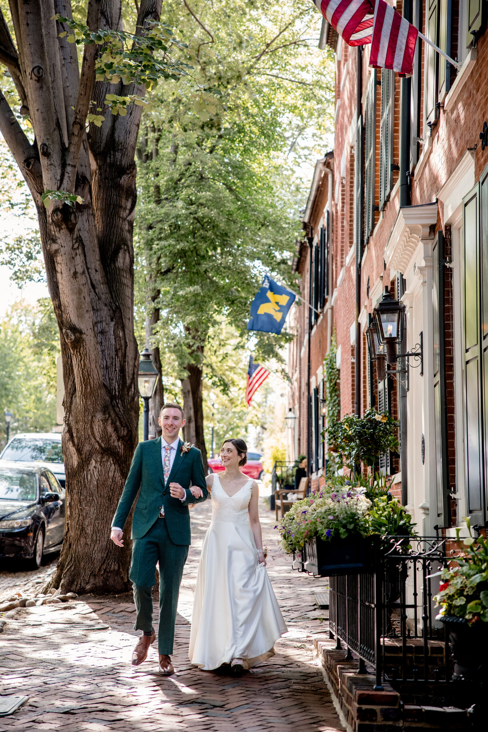 a couple walking arm in arm on their wedding day through old town alexandria 