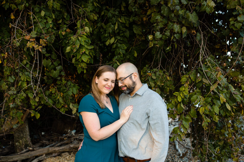 A couple with their arms around each other leaning their heads together 