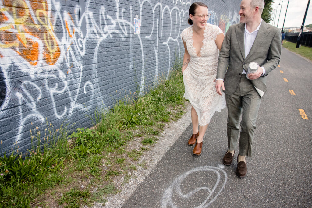 A couple laughing as they walk down a bike trail in the city 
