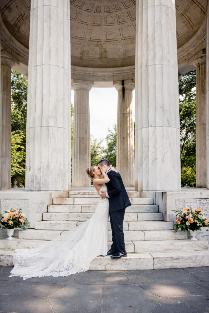 Newlyweds kissing in front of a gazebo 